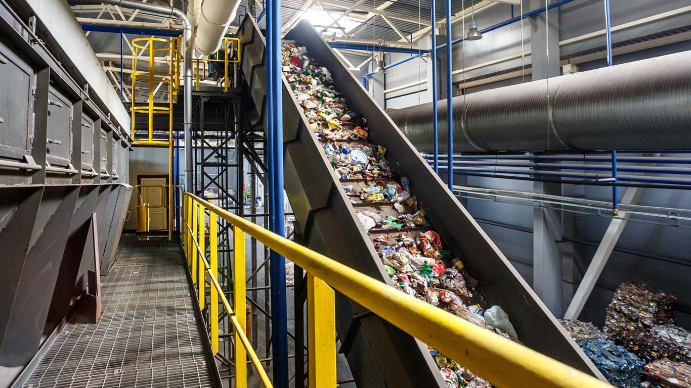 Déchets plastiques sur un tapis roulant dans une usine de recyclage des déchets